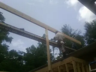 Carpenter setting a ridge beam over a new addition frame — Ice Dam Removal by Roofing Brothers in Kearny